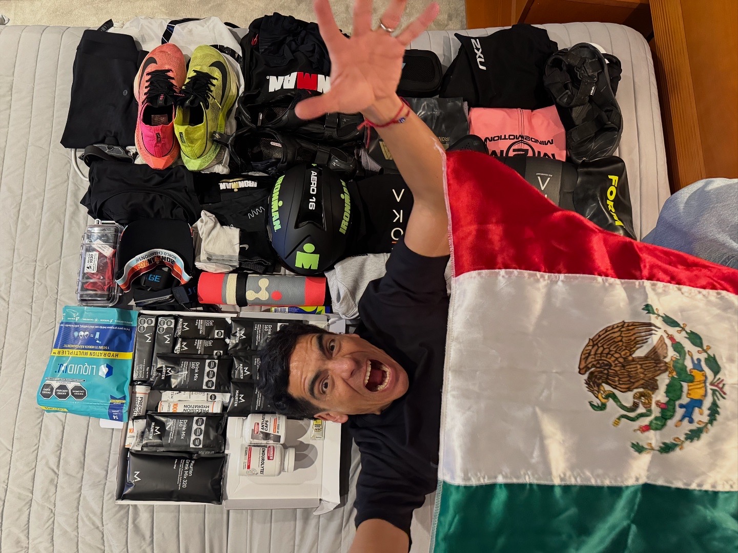 Equipo de competencia preparado sobre la cama junto a una bandera de México.