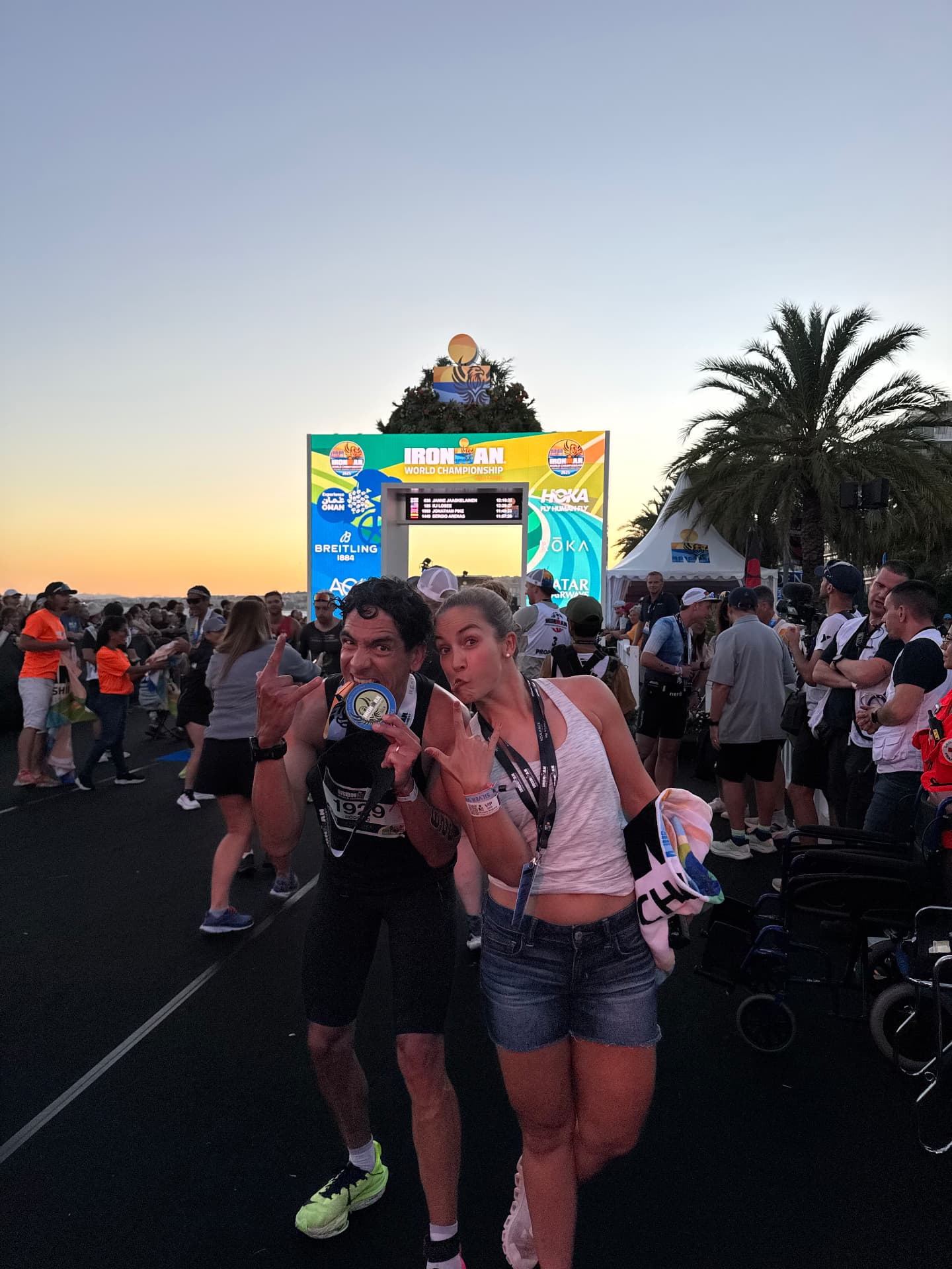 Rodrigo mordiendo su medalla junto a Rox frente al arco de meta.