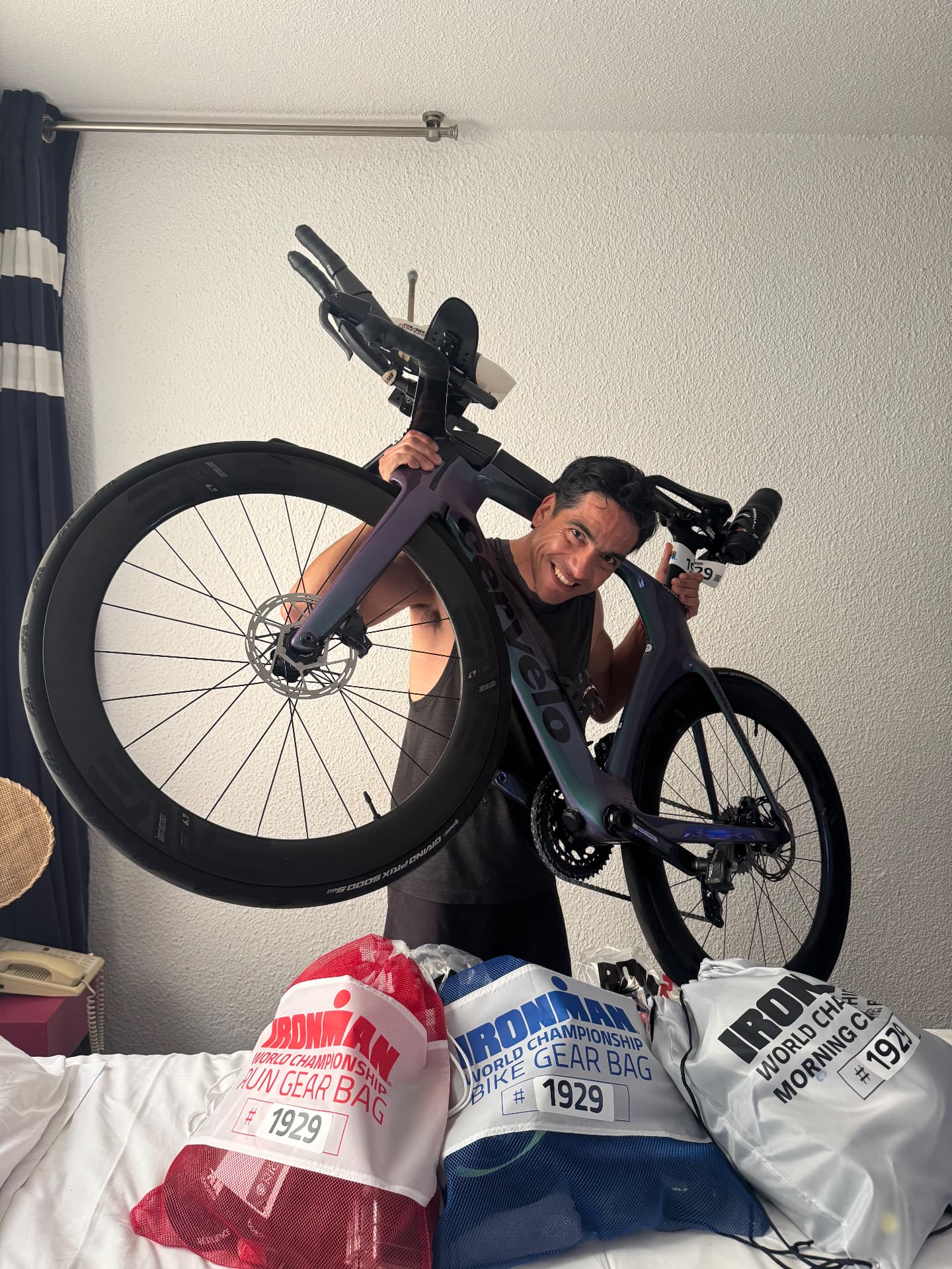 Rodrigo cargando su bicicleta de contrarreloj junto a las bolsas de transición numeradas.