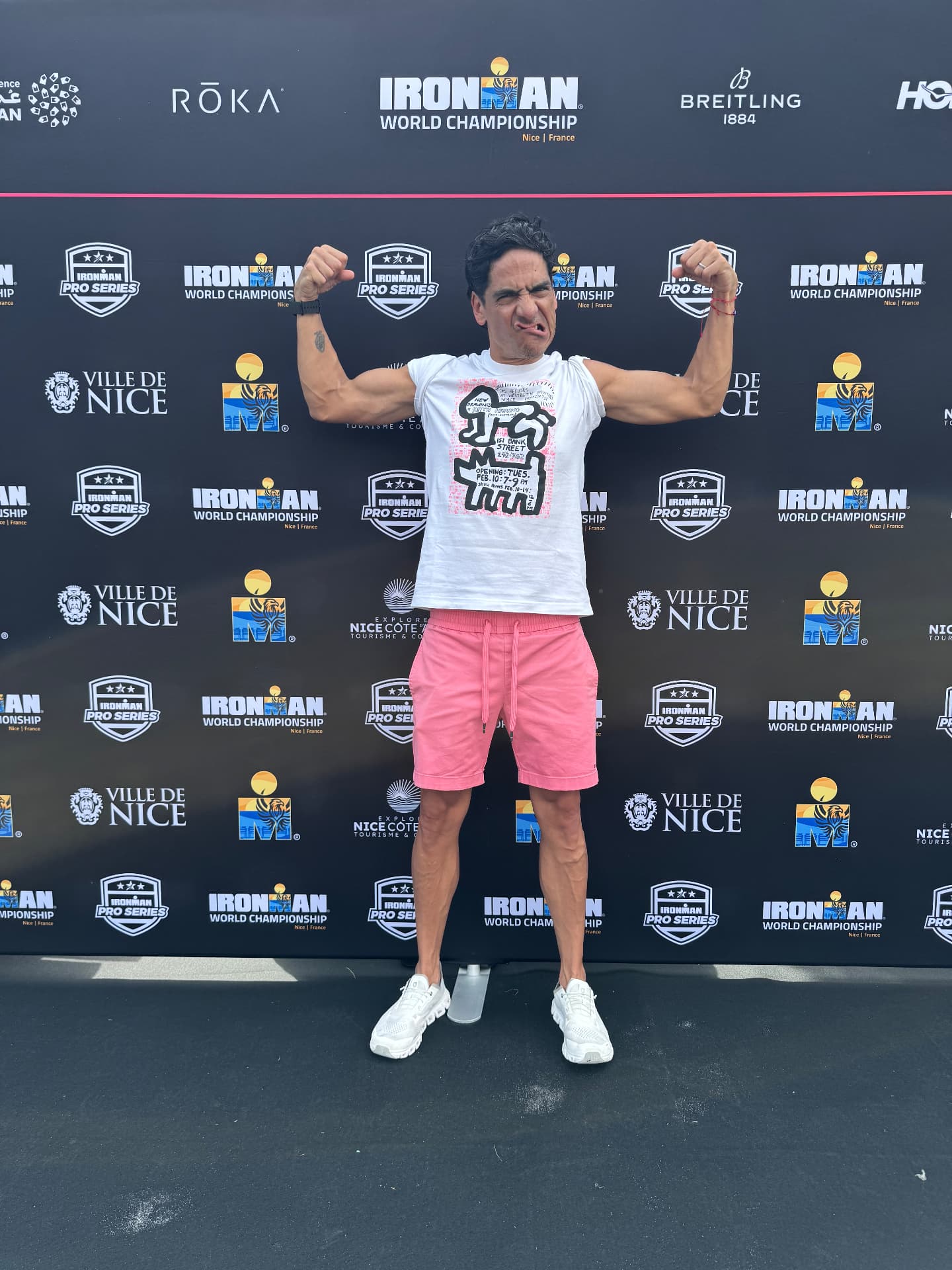 Rodrigo posando con los brazos flexionados frente al muro del Ironman World Championship.